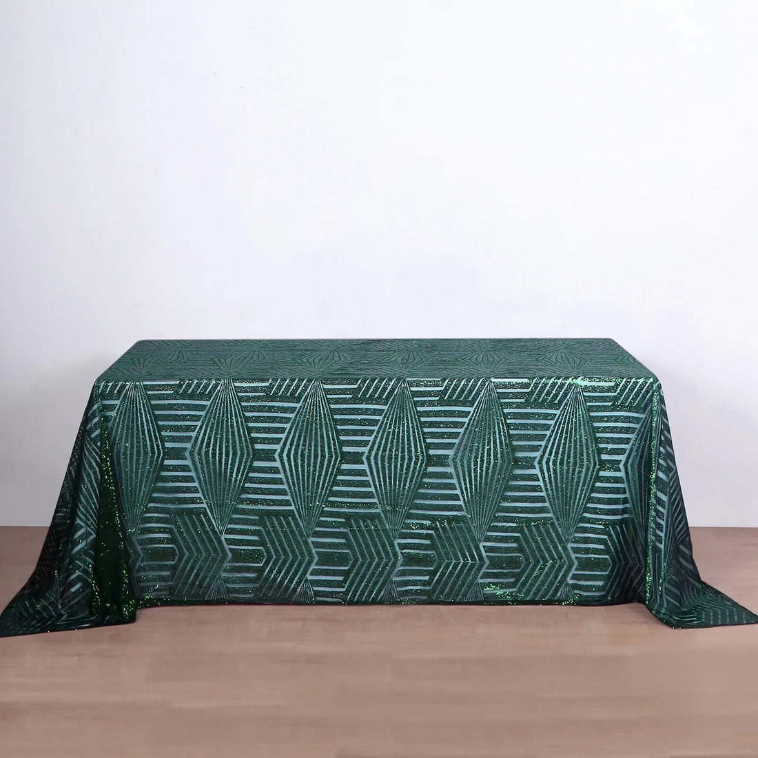 Green patterned tablecloth with geometric design on a plain background.