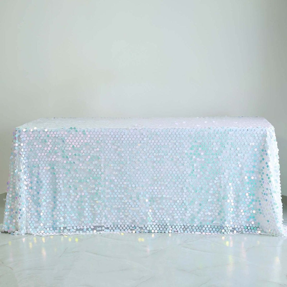 Sequin tablecloth in iridescent colors on a plain background