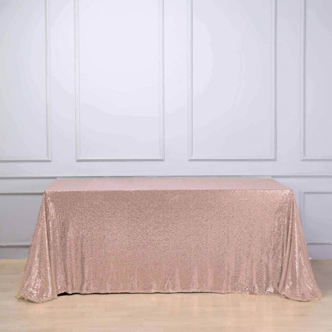 Rose gold sequin tablecloth on a plain backdrop.