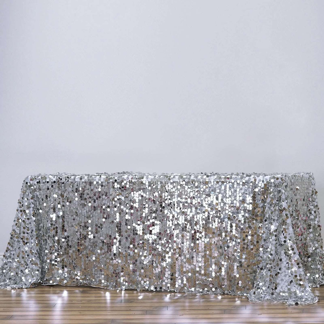 Silver sequin tablecloth draped on a table.