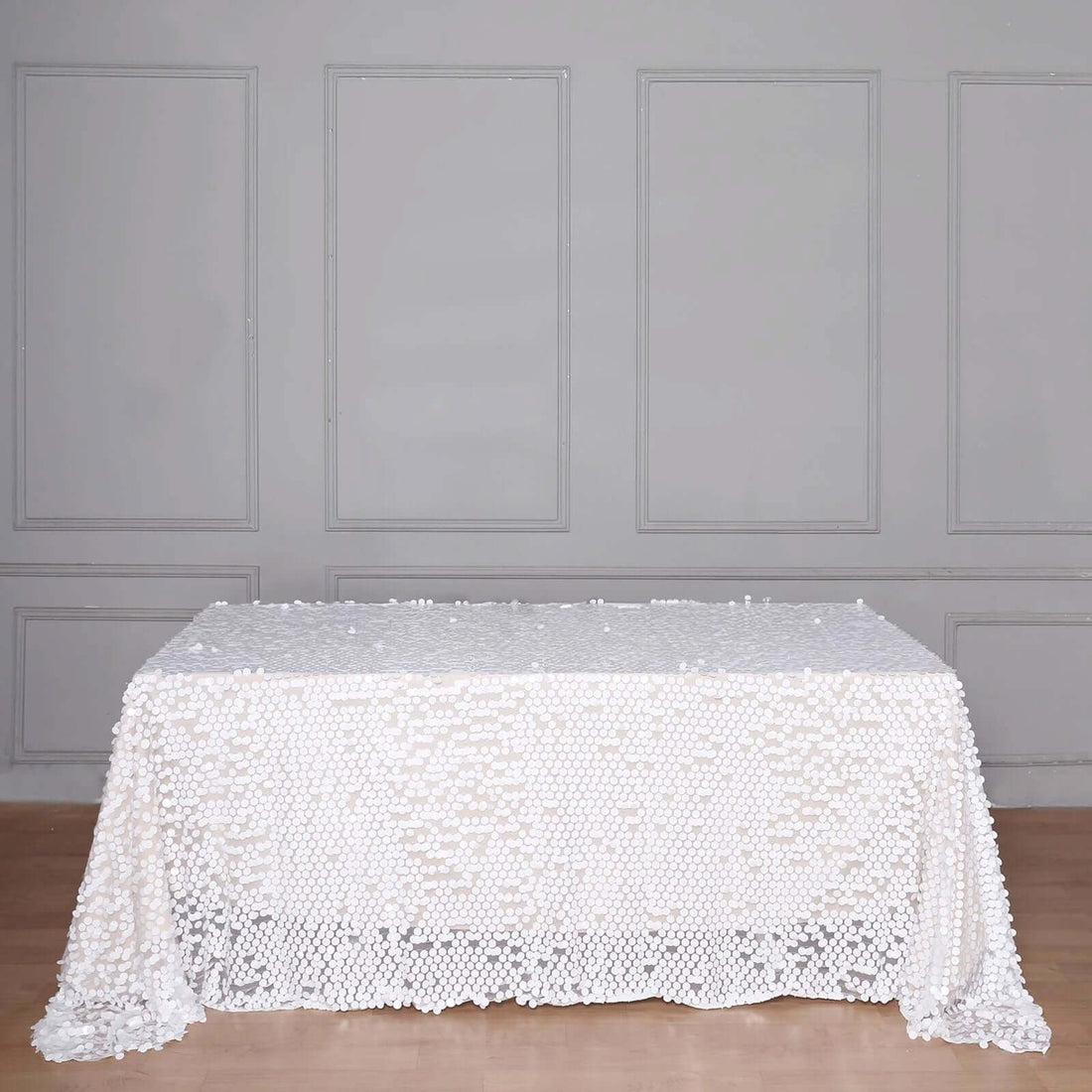 White tablecloth adorned with textured details on a plain backdrop.