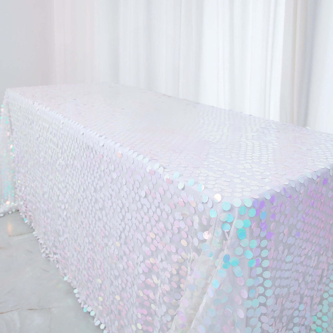 Iridescent sequin table cover on a white backdrop