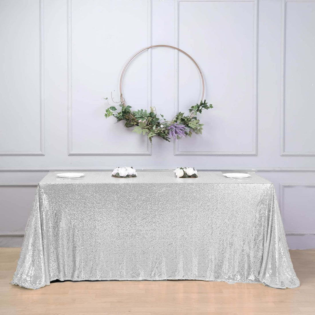 Silver sequin tablecloth draped elegantly on a table with floral decor.