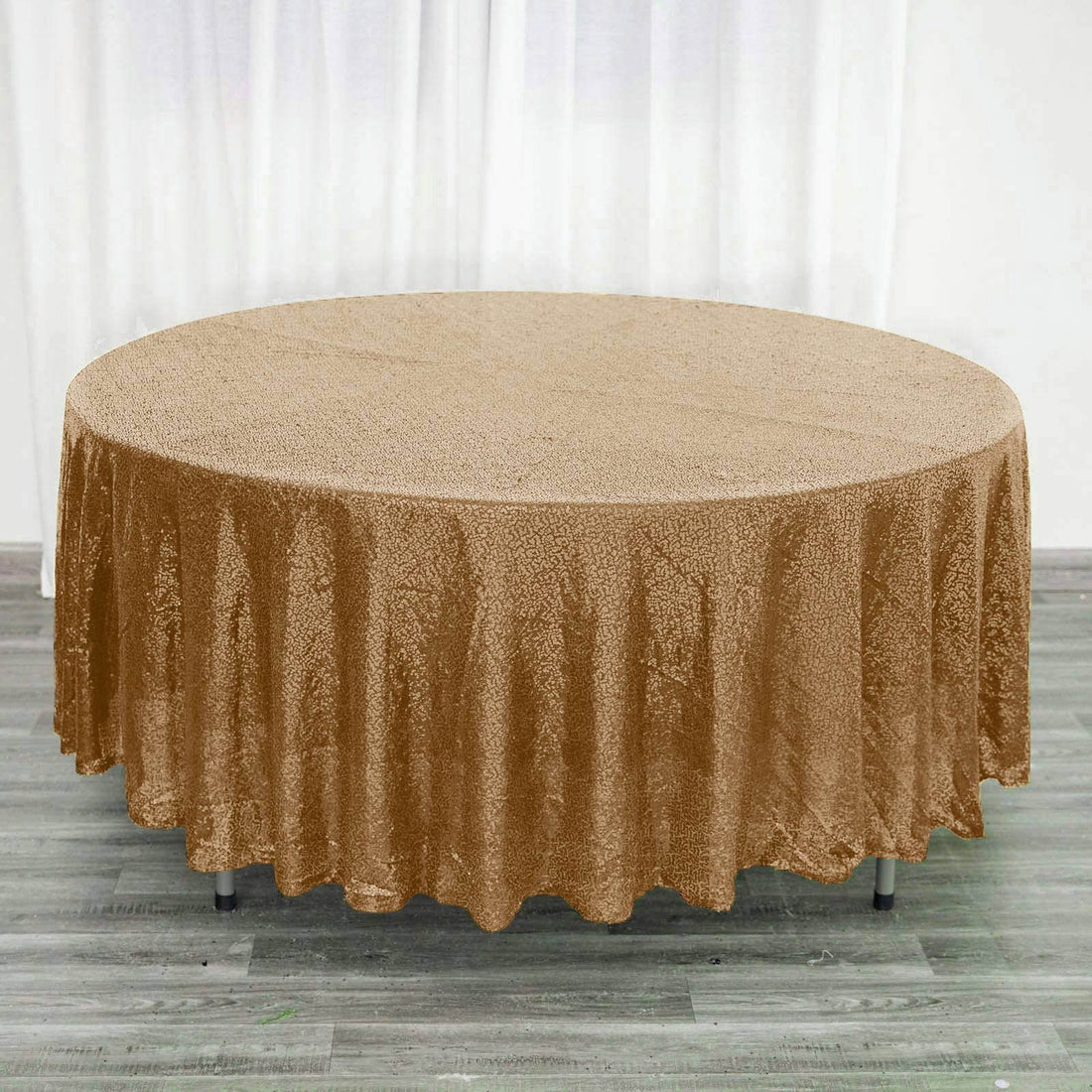 Brown round tablecloth with shimmering texture on a wooden floor.