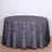 Round black and silver patterned tablecloth on a wooden surface.