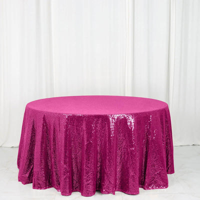 Round fuchsia sequin tablecloth on a white backdrop