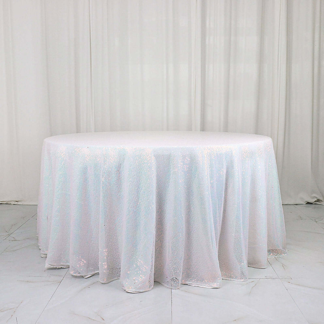 Round sequin tablecloth in iridescent white on a plain background.