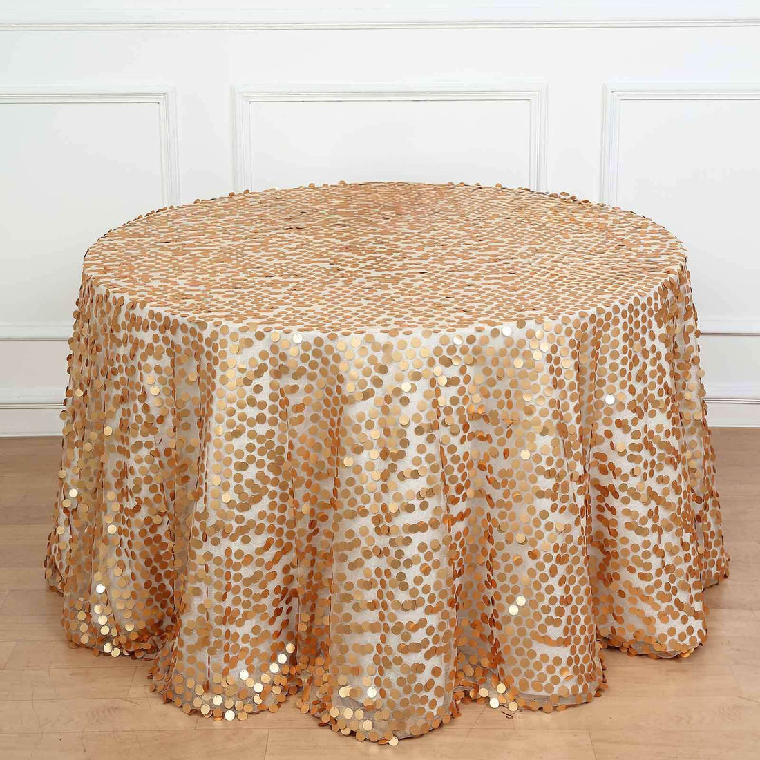 Gold sequin tablecloth with circular patterns on a round table.