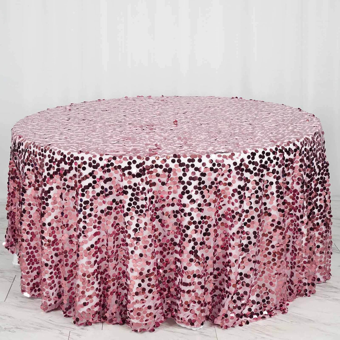 Pink sequin tablecloth with a circular design and shimmering texture.