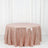 Rose gold sequin tablecloth on a round table against a white backdrop
