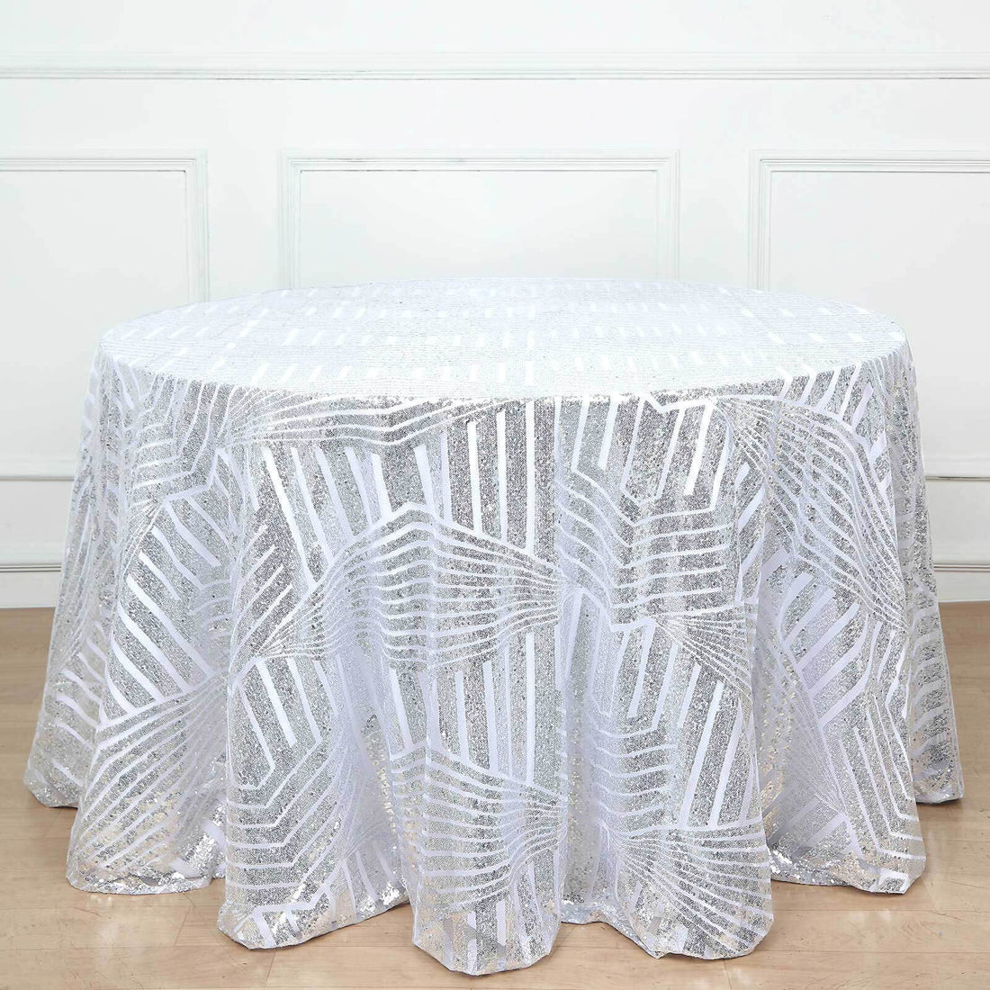 Silver sequin tablecloth with leaf pattern on a round table.