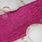 Pink sequin table runner with white plates and glassware on a table.