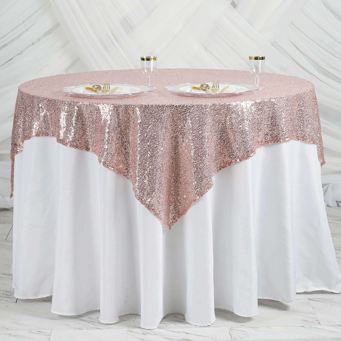 Rose gold sequin tablecloth draped elegantly over a white table.