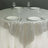Silver sequined tablecloth on a round table set with plates and glasses.