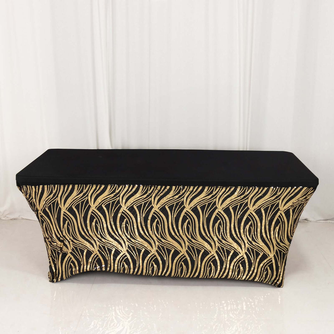 Black and gold wave-patterned table cover on a plain background.