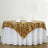 Gold sequin tablecloth draped over a round table with wine glasses and napkins.