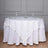 White tablecloth with sequined overlay on a round table setting.