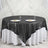 Black sequin tablecloth on round table with plates and glasses