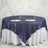 Navy sequin tablecloth draped over a round table with plates and glasses