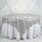 Round silver sequin tablecloth draped elegantly over a white table.