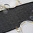 Elegant black table runner with gold detailing, styled with fine dishware.