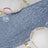 Textured blue table runner with elegant gold-accented dinnerware.