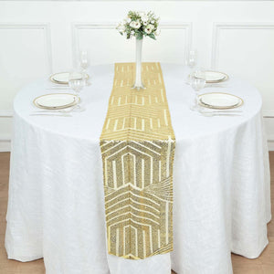 Gold geometric table runner on a white table setting with plates and glasses.