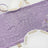 Purple sequin table runner with elegant dinnerware and glasses.