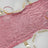 Pink sequin table runner on a dining table with elegant plates and glasses.