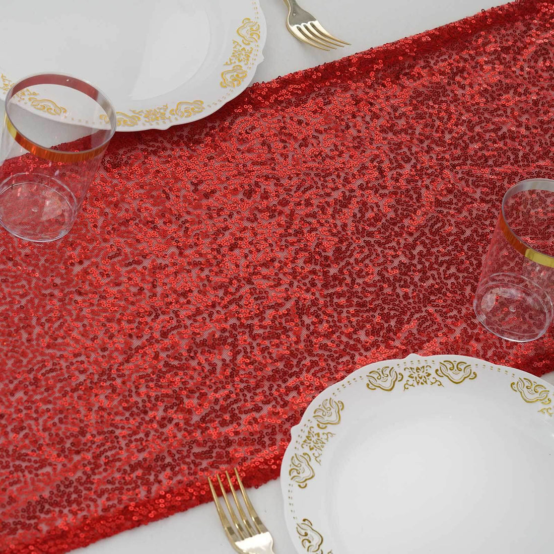 Red sequin table runner with gold accents on white table setting