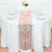 Elegant rose gold table runner on a white table with decorative centerpiece.