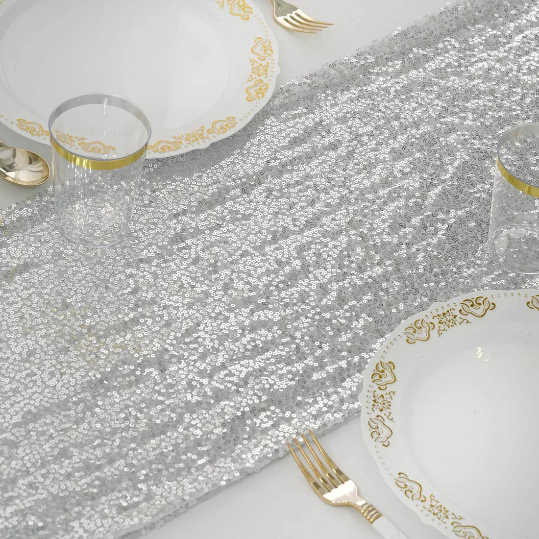 Silver sequin table runner with elegant gold-accented dinnerware.