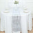 Elegant silver and white table runner on a round dining table with glassware.