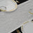 Elegant silver table runner with gold-accented plates and glasses.