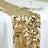 Gold sequin table runner on a white tablecloth for elegant decor.