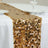 Gold sequin table runner on a white table with plates and glasses