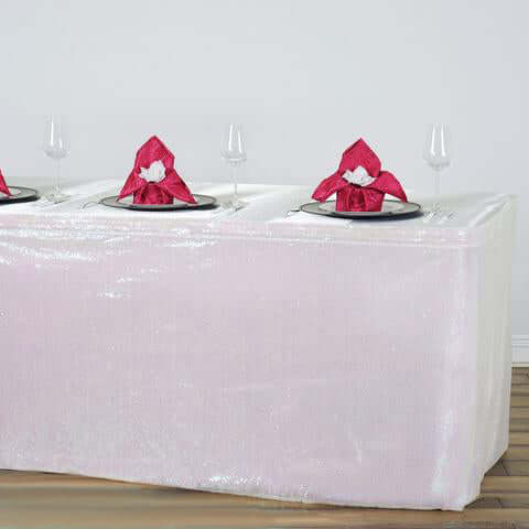 Elegant pink table cover with decorative napkins and glassware.