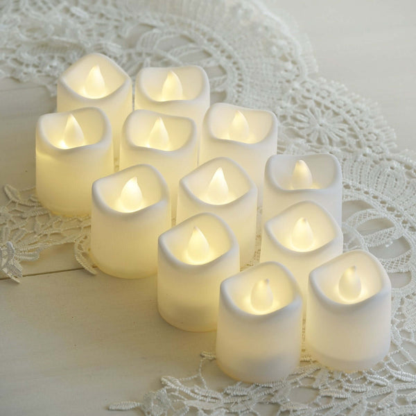 Set of 12 flameless LED candles in various heights, soft warm glow.