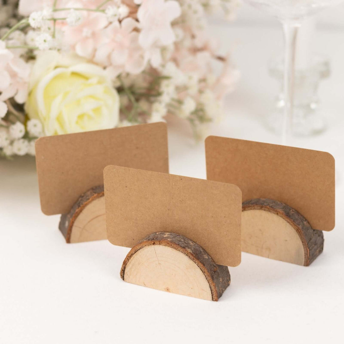 Wooden card holders with blank kraft cards for table settings.