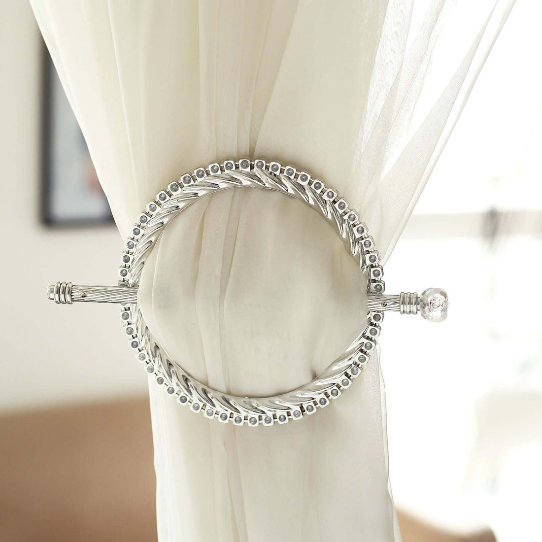 Silver curtain ring holder with decorative bead design.