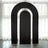 Black arch backdrop with gold stands for events and photography.