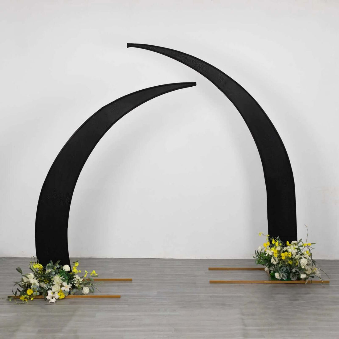 Black curved arch with floral arrangements at the base.