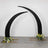 Black curved arch with floral arrangements at the base.
