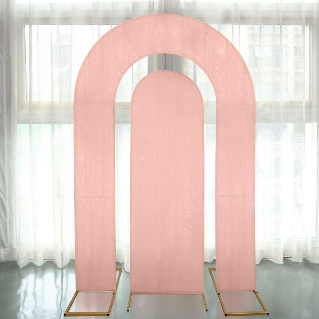 Pink arch backdrop display in a studio setting with sheer curtains.