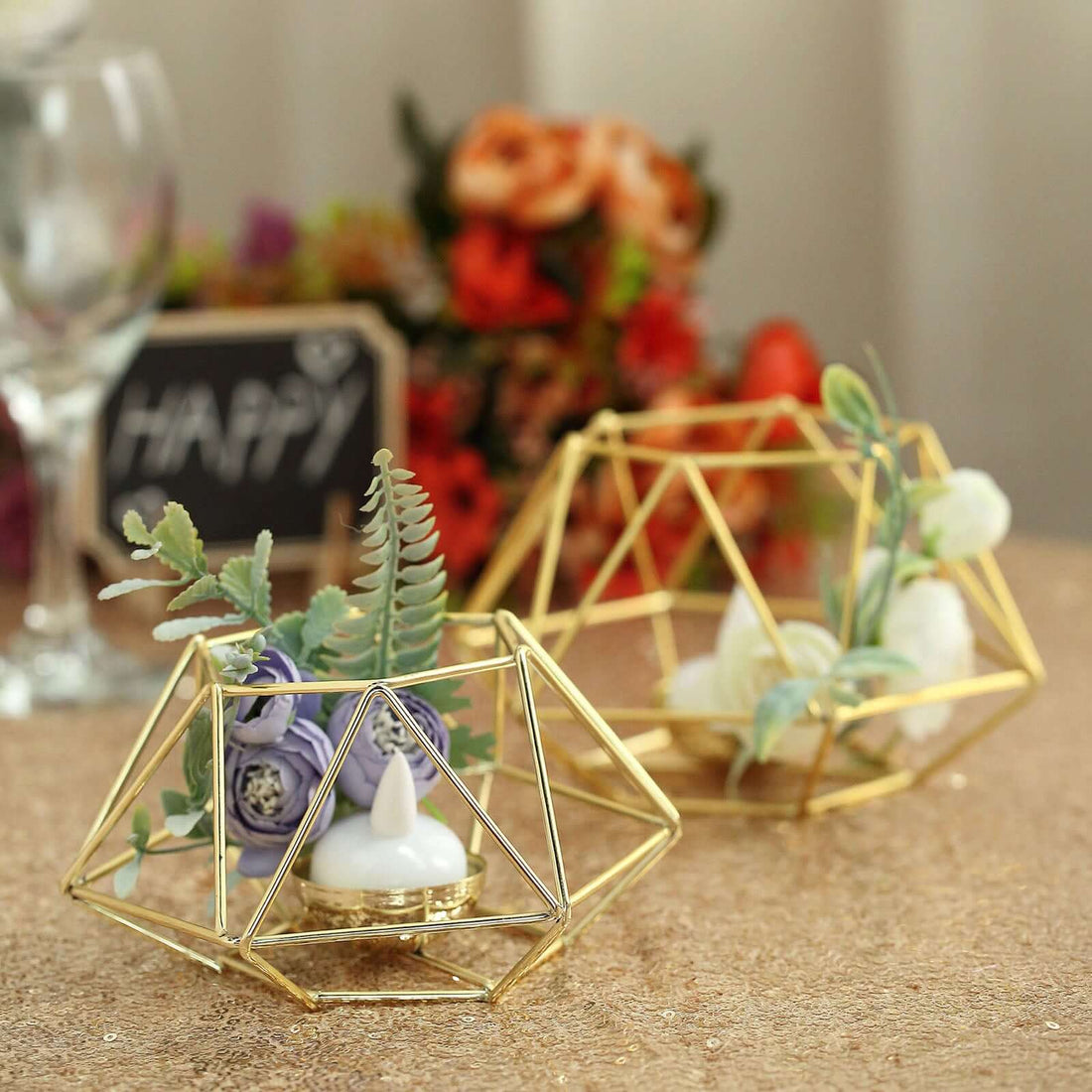 Geometric gold candle holders with flowers on a table setting.