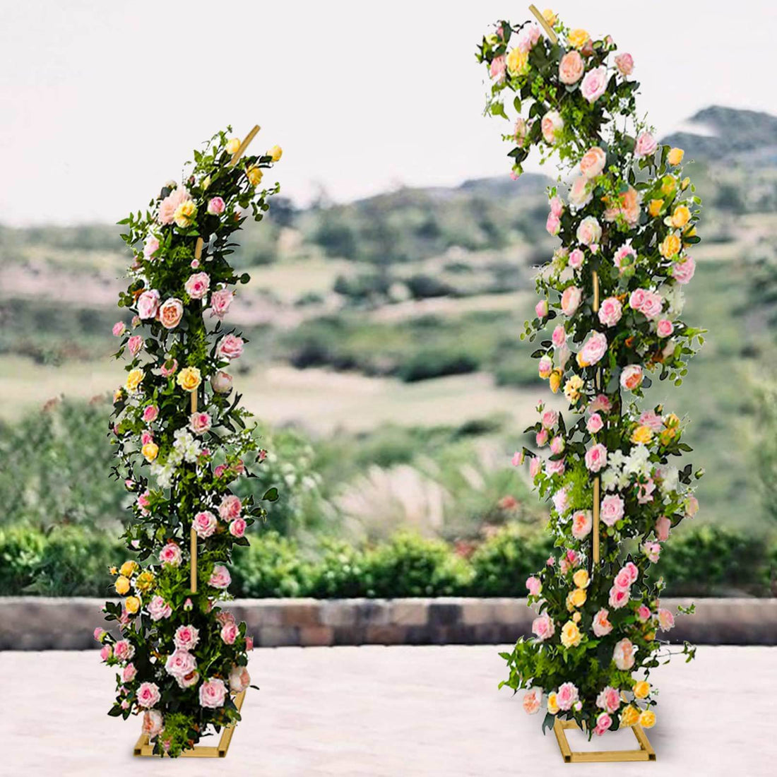 Floral archway display with pink and yellow roses in outdoor setting.