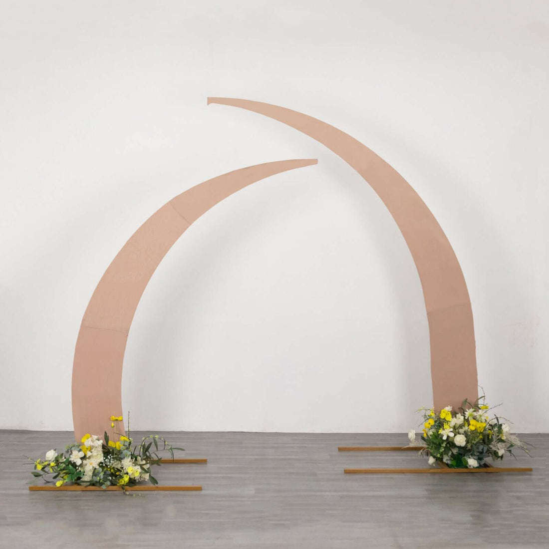 Curved wedding arch with floral arrangements at the base