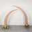 Curved wedding arch with floral arrangements at the base