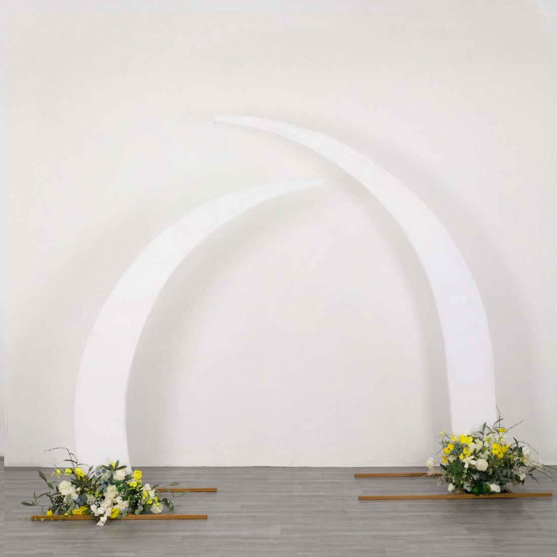 White curved arch with floral arrangements at the base