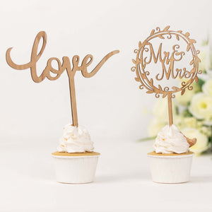 Wooden cupcake toppers "love" and "Mr & Mrs" on white cupcakes.